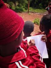 School boy in Kenya taking notes.