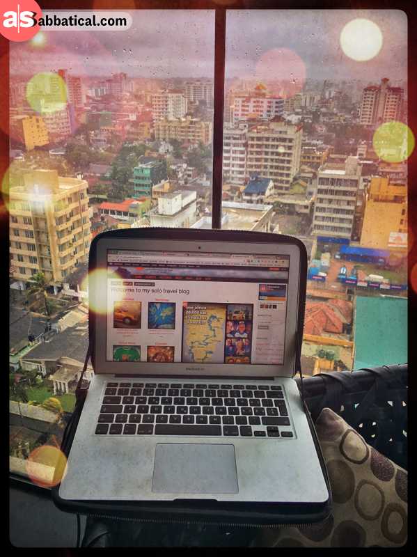 digital nomad adrian sameli working with a mac book air from a sky bar